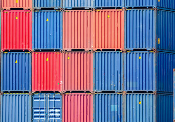 Four vertical rows of shipping containers that are different colors in the Port of Zeebrugge, Belgium