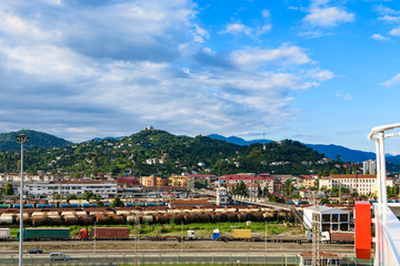 Port of Batumi, Georgian resort city and port at Black Sea – panoramic view of surrounding mountains from cargo ship in port in golden summer morning sunlight