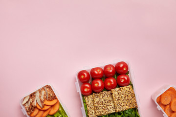 flat lay with healthy food arranged in food containers isolated on pink