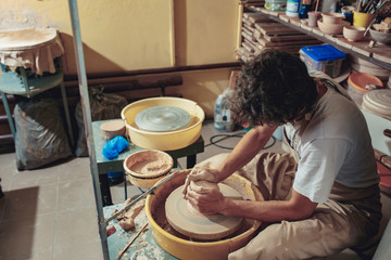 Creating a jar or vase of white clay close-up. Master crock. Man hands making clay jug macro.