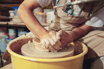 Creating a jar or vase of white clay close-up. Master crock. Man hands making clay jug macro.