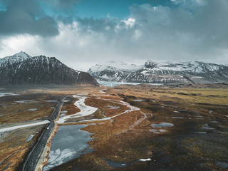 Vatnajokull glacier aerial drone image with street highway and clouds and blue sky. Dramatic winter scene of Vatnajokull National Park, Iceland, Europe. Beauty of nature concept background.