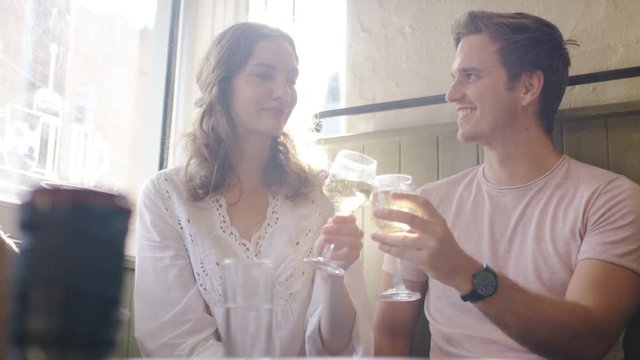 Young couple having a drink together in a bar, in slow motion