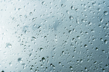 Textured background of window panes with a cloudy background. Natural pattern from a drop of rain on a cloudy background.