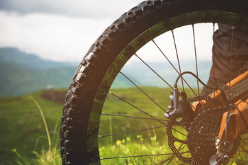 Close-up view of rear wheel cassette from mountain bike on the landscape and green grass