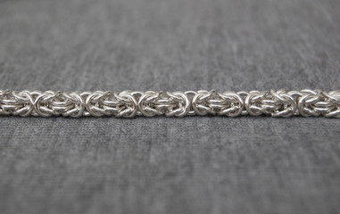 Silver chain on textile background, denim texture