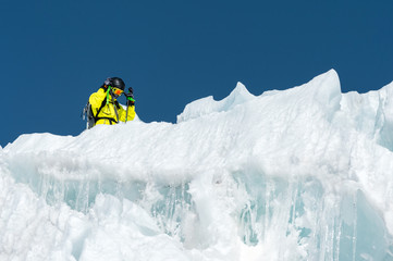 A freerider skier in complete outfit stands on a glacier in the North Caucasus. Skier preparing before jumping from the glacier
