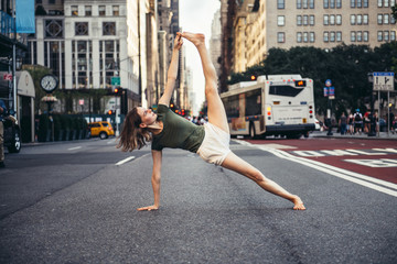Fototapeta na wymiar Woman dong yoga pose in the city street of New York