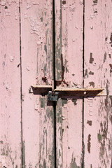 Old pink door grunge textured with rusty lock