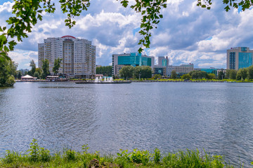 Fototapeta na wymiar a panorama of a pond with fountains and to the opposite shore with new high-rise buildings