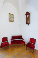 red sofa and two armchairs pattern and antique clock