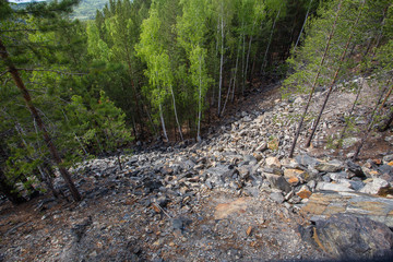 abandoned ore mine shaft slagheap in green forest