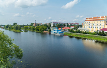 Obraz premium A large transparent blue river against a backdrop of beautiful buildings and a green green area