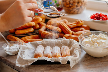 Homemade eclairs. Preparation of eclairs in the home kitchen. The process of cooking eclairs.Eclair a small, soft, log-shaped pastry filled with cream and typically topped with chocolate icing.