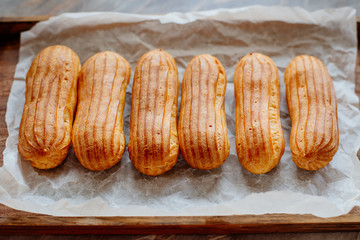 Homemade eclairs. Preparation of eclairs in the home kitchen. The process of cooking eclairs.Eclair a small, soft, log-shaped pastry filled with cream and typically topped with chocolate icing.