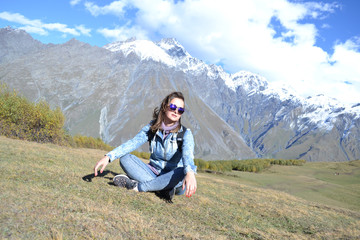 Naklejka premium Woman in sunglasses looking into camera in front of Kazbegi mountains, Georgia