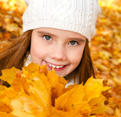 Autumn portrait of adorable smiling  little girl child with leaves