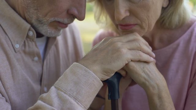 Elderly people lean on walking stick, concept of support, strong marriage, love