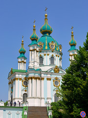 Fototapeta na wymiar Beautiful massive church with green gilt domes on a clear blue sky background