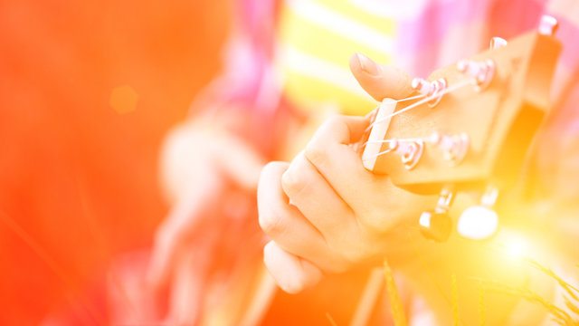 hands playing a guitar close-up