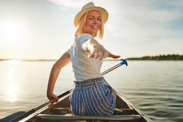 Smiling woman canoeing on a scenic lake in the summer