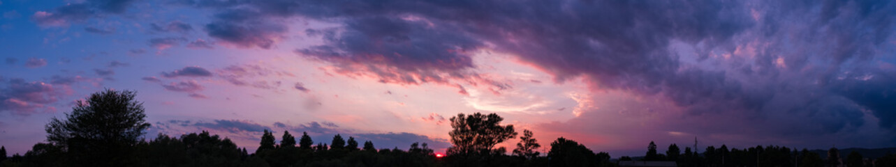 Dark sky panorama with violet sunset clouds