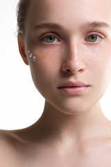 Naklejka premium The beautiful young woman the blonde with an ideal thin skin and natural cosmetics. Cream on a face. Cosmetology, Spa procedures. Purity and grace.