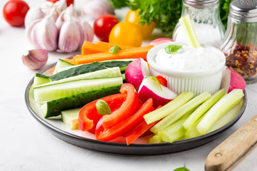 Vegetable sticks of cucumber, pepper, carrots, celery and radishes with white sauce of sour cream, yogurt, herbs.