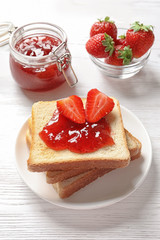 Tasty toast bread with strawberry jam and fresh berries on light background