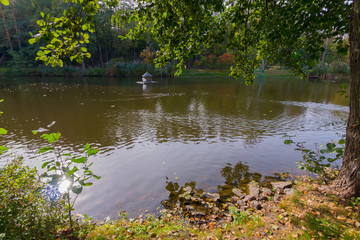 Autumn pond on the berg, which float multi-colored fallen leaves. The water is still warm, but it's already getting cold