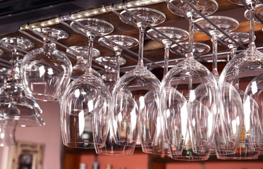 Clean glasses hanging over counter in bar
