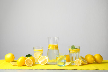 Composition with lemon water and fresh fruits on table