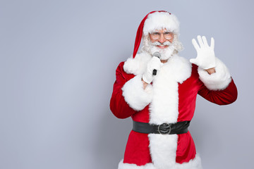 Santa Claus singing into microphone on color background. Christmas music