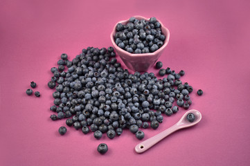 Blueberries with bowl and spoon stock images. Blueberries in a bowl. Blueberries on a purple background. Healthy summer fruit
