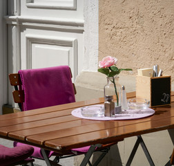 Coffee table with flower outside in the sunlight