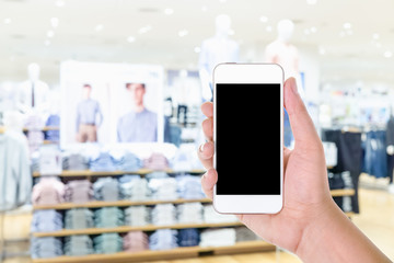 Man hand holding and using blank screen mobile smart phone with blurred background fashion shop in shopping mall