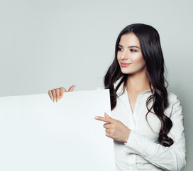 Business woman pointing up her finger and showing signboard with blank copy space area for...