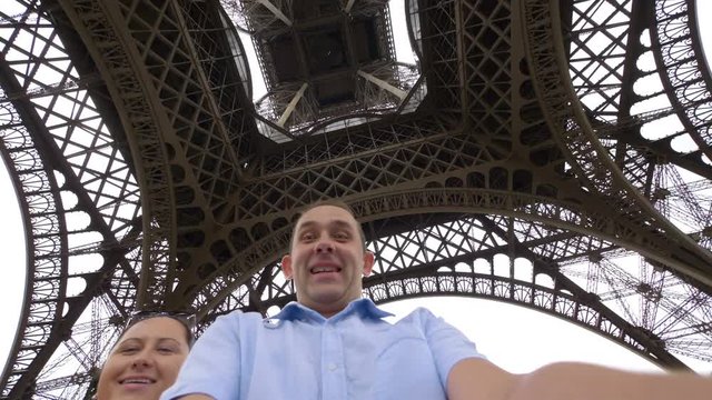 Professional video of happy man and woman spinning and having fun under the Eiffel tower in Paris in 4k slow motion 60fps