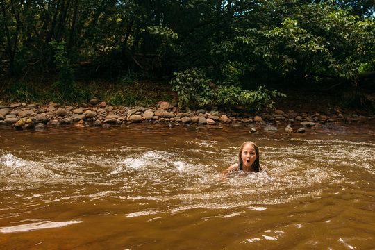 Young Girl Swimming in Riverbed