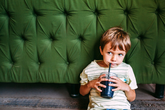 Young Boy Drinking in front of Couch