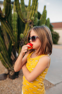 Profile of Girl Eating in Front of Cactus