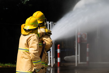 Group of firefighters advance forward putting out a fire..