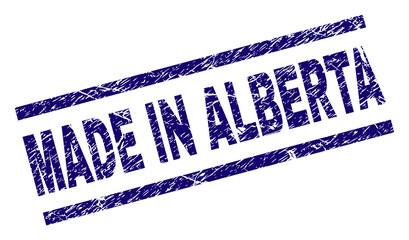 MADE IN ALBERTA stamp seal watermark with grunge style. Blue vector rubber print of MADE IN ALBERTA caption with grunge texture. Text label is placed between parallel lines.