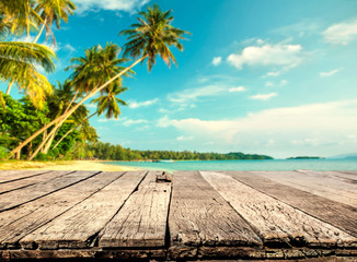 Wood table with blurred sea and coconut tree background