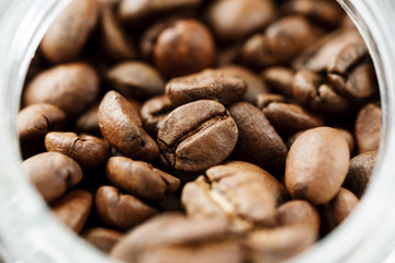 Roasted coffee beans inside jar macro shot