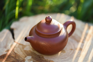 Small Chinese clay teapot for tea ceremony on wood slab in morning light