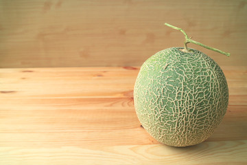 Fresh Ripe Cantaloupe Melon or Muskmelon Whole Fruit with Stem Isolated on Wooden Table 