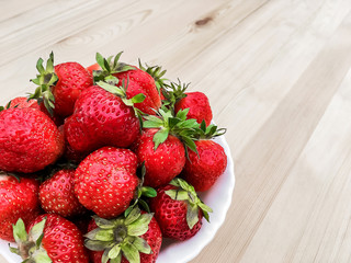 Cup of strawberries on wooden background