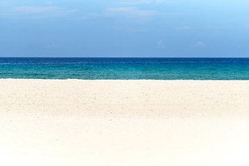 Fototapeta na wymiar White sand, deep blue sea and the sky on sunny day with copy space