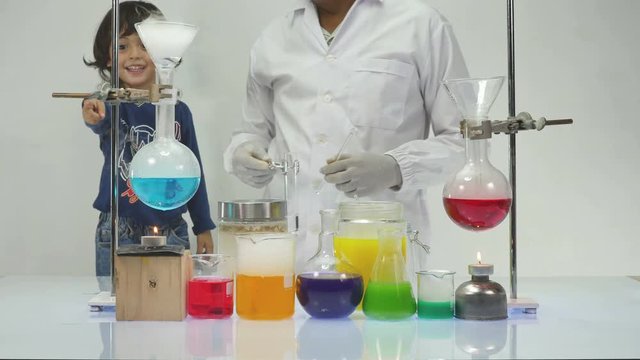 a children interested in colorful of chemical mixing in laboratory experiments